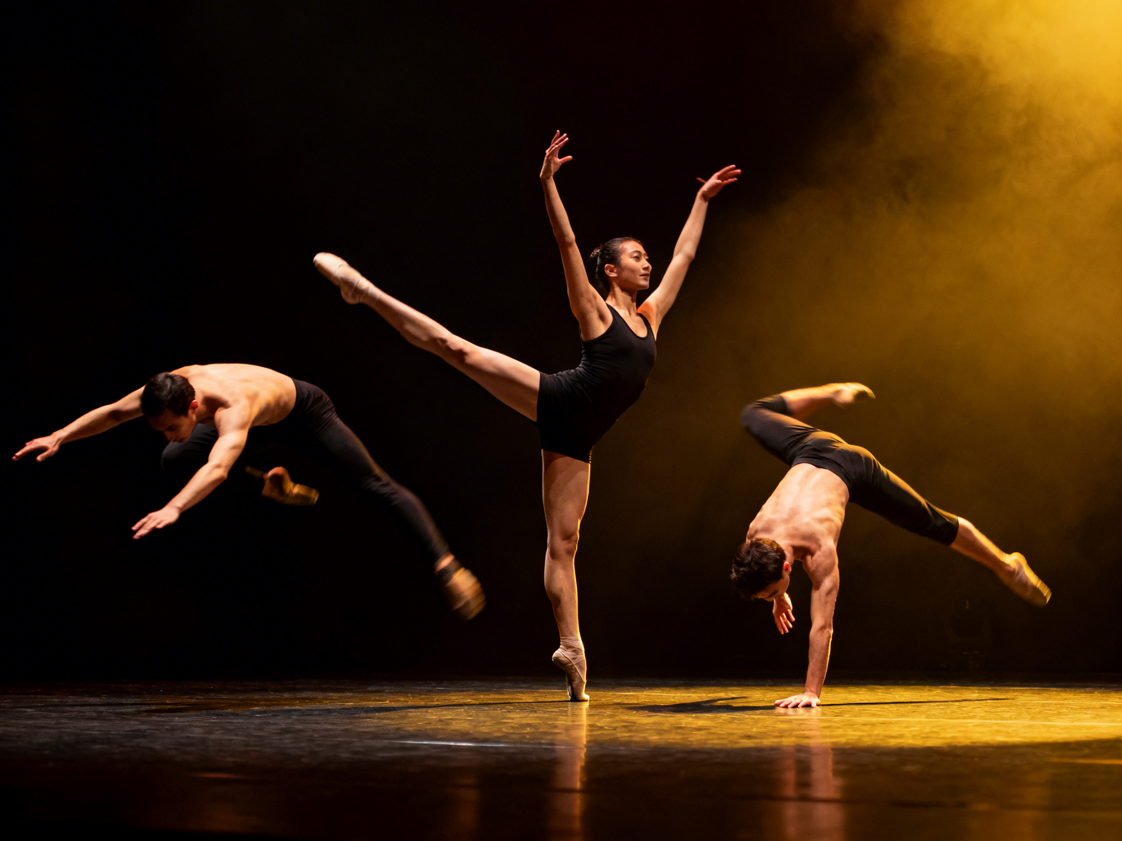 画面中展示了三位舞者在漆黑的舞台上表演现代芭蕾的瞬间。背景右侧有暖黄色的灯光和烟雾效果，为画面增添了动感与张力。中心是一位穿着黑色连体衣的女性舞者，她单脚伫立，另一条腿高高抬起，双臂向斜上方舒展，姿态优雅。她左侧的一位男性舞者正处于跃起的动态中，赤裸上身，身体前倾；右侧另一位男性舞者则单手撑地，身体倒立翻转。画面整体色调深沉，光影对比强烈，强调了舞者的肌肉线条。

然而，图中存在多处明显的 AI 生成缺陷：左侧跃起男性的腿部结构混乱，出现了多余且模糊的脚部重影，且其左手手指扭曲不自然；中间女性舞者支撑地面的脚尖与地板接触处透视生硬，且她高举的右手手指数量异常且细长；右侧倒立男性的支撑手掌与地面接触点显得扁平，缺乏真实的受力感。这些逻辑错误揭示了图像并非真实摄影。