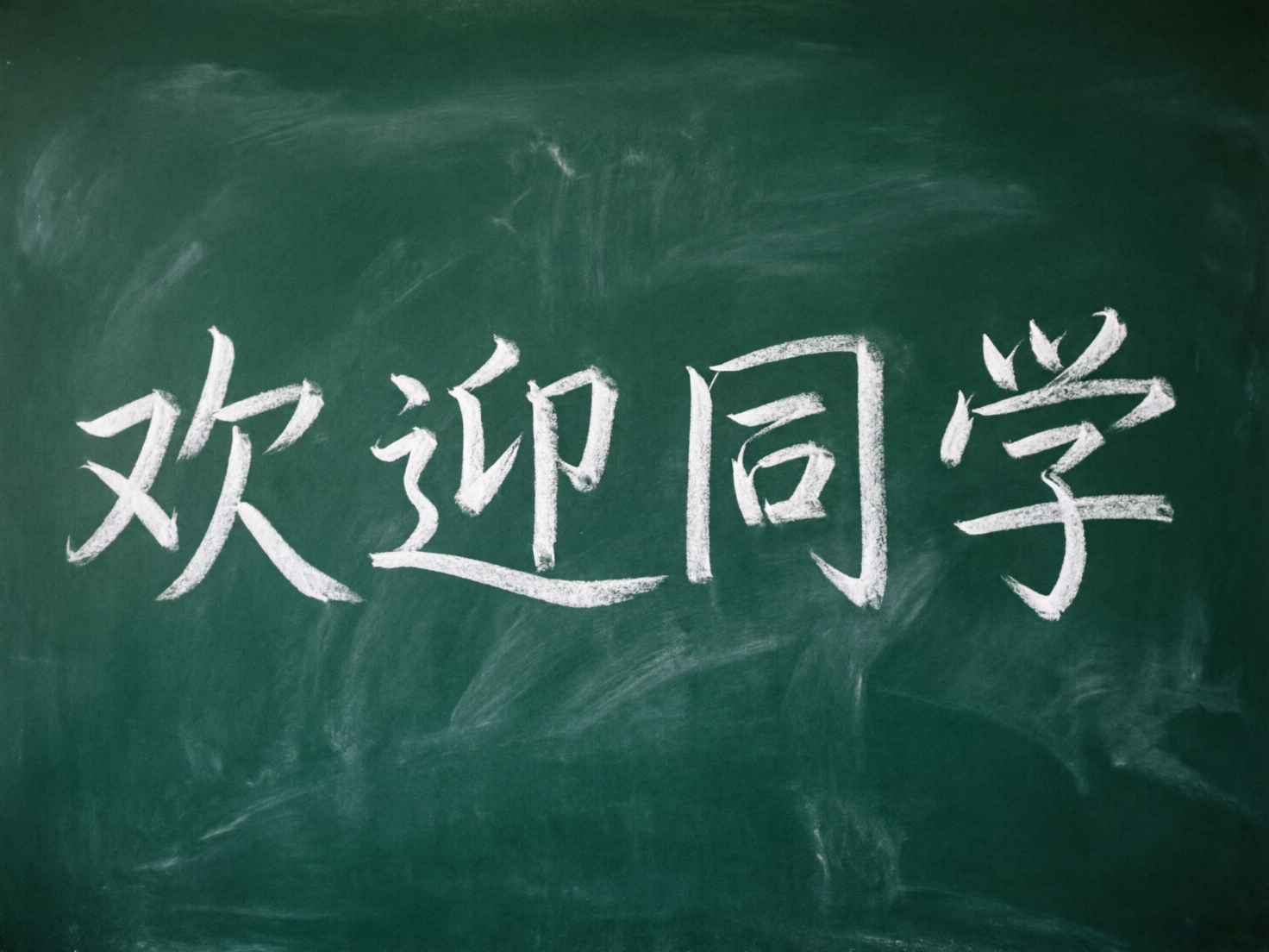 图中展示了一块深绿色的黑板，黑板中心位置用白色粉笔书写着“欢迎同学”四个大字。字迹模仿了手写粉笔的质感，带有明显的笔触和粉末摩擦的痕迹。黑板背景并非纯净的绿色，而是布满了粉笔擦拭后留下的白色粉尘痕迹，营造出一种真实的教室氛围。构图简洁明了，文字居中，视觉重心非常突出。

然而，作为一张 AI 生成的图片，画面中存在明显的文字结构缺陷。首先，“欢”字的左半部分结构扭曲，笔画连接生硬且不符合汉字书写逻辑；“迎”字的走之底处理得非常模糊，缺乏应有的笔锋；“同”字的内部结构显得拥挤且歪斜；“学”字顶部的三个点演变成了杂乱的线条，底部的“子”部也出现了笔画断裂和变形。这些细节暴露了 AI 在处理复杂汉字结构时的局限性，导致文字看起来虽有其形，但经不起仔细推敲。