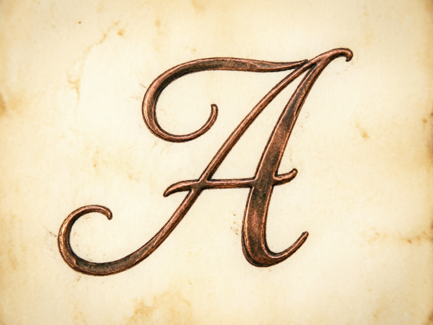 图中展示了一个优雅的花体大写字母“A”，它位于画面的中心位置。这个字母呈现出一种古铜色或红铜色的金属质感，表面带有细腻的拉丝纹理和明暗变化的金属光泽，仿佛是镶嵌在背景之上的浮雕。背景是一张泛黄且带有斑驳污渍的复古羊皮纸，色调温暖，边缘略显模糊，营造出一种陈旧的历史感。字母的线条流畅，带有华丽的卷曲装饰，整体构图简洁而具有艺术气息。在 AI 生成的细节方面，可以观察到字母右侧斜杠的末端收尾略显生硬，与主干的连接处存在细微的结构不自然，且字母边缘的阴影处理在不同部位表现得不够一致，导致局部立体感略显失真，但整体视觉效果依然保持了较好的美观度。