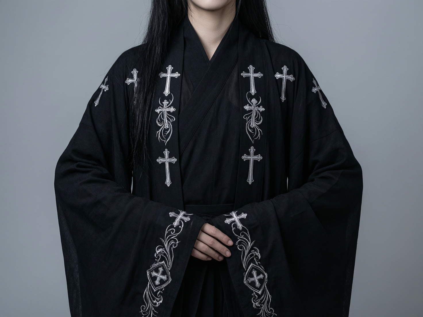 图中展示了一位留着黑色长直发的女性半身像，背景为纯净的浅灰色。她身着一件极具哥特风格的黑色中式交领长袍，衣袖宽大，整体色调深沉肃穆。长袍的领口、肩膀以及袖口处点缀着精细的银白色刺绣，图案以十字架为主，并辅以卷曲的藤蔓花纹。女子的双手交叠放在腹前，指尖修长。

在 AI 生成的细节方面，存在一些明显的逻辑缺陷：首先是手部处理异常，画面中心交叠的手指数量和关节连接显得生硬且不自然，左手手指似乎多出了一截；其次，衣服上的十字架刺绣分布缺乏透视规律，部分图案显得过于扁平或扭曲，尤其是肩膀处的十字架与布料褶皱的衔接不够真实；此外，人物的颈部线条与衣领的交界处处理得过于平滑，缺乏自然的阴影过渡。