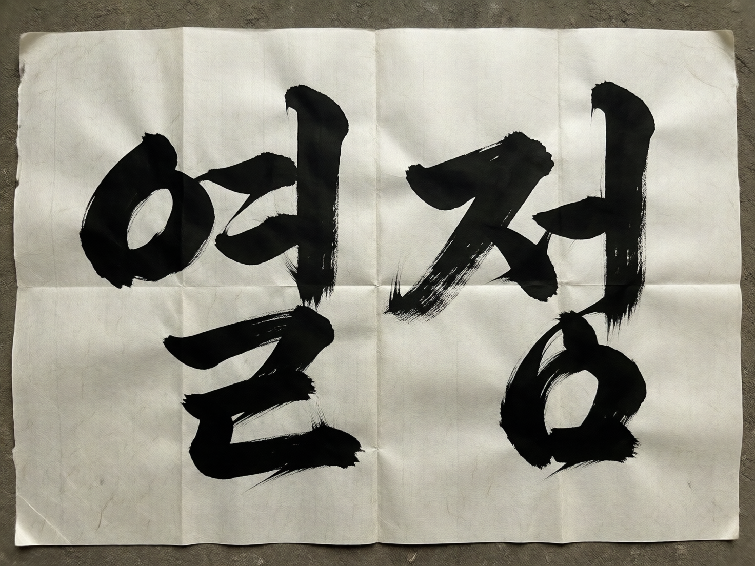 图中展示了一张铺在灰色粗糙地面上的白色宣纸，纸上用黑色毛笔书写着两个巨大的韩文字符。纸张呈现出明显的折痕，将其横竖划分为六个矩形区域，边缘略显不平整，模拟了真实纸张的质感。书法笔触雄健有力，带有明显的飞白效果，展现出传统水墨的韵味。然而，作为一张 AI 生成的图片，画面存在明显的逻辑缺陷：这两个字符虽然看起来像韩文，但实际上是扭曲且无意义的符号组合。左侧字符的上半部分像是一个变形的圆圈连接着不规则的撇画，下半部分则是一个生硬的折线；右侧字符的结构同样支离破碎，笔画之间的衔接违背了真实的汉字或韩字书写规律。此外，纸张上的折痕在经过墨迹时，墨水的浓淡变化并未随折痕起伏产生合理的物理形变，显得不够自然。